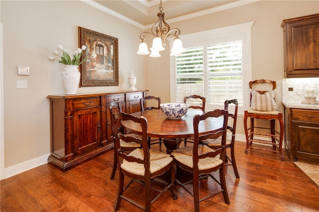 dining room featuring dark hardwood / wood-style flooring, ornamental molding, and an inviting chandelier