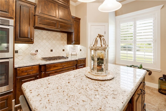 kitchen with a wealth of natural light, crown molding, appliances with stainless steel finishes, and custom exhaust hood