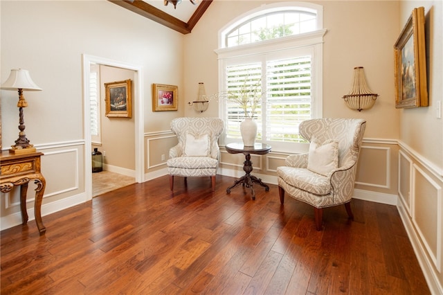 living area with a healthy amount of sunlight, vaulted ceiling, and hardwood / wood-style flooring