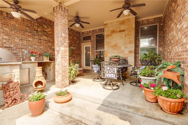 view of patio with ceiling fan and exterior fireplace