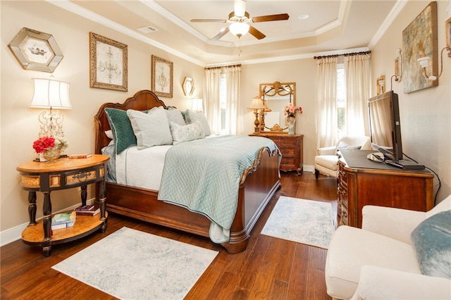 bedroom featuring a raised ceiling, ceiling fan, dark hardwood / wood-style flooring, and ornamental molding