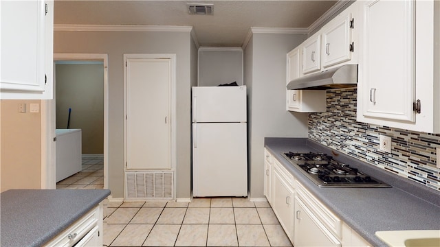 kitchen with white fridge, white cabinetry, stainless steel gas stovetop, and light tile patterned flooring