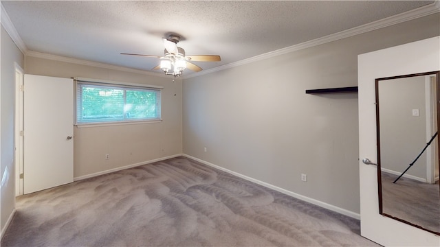 carpeted spare room featuring a textured ceiling, ceiling fan, and ornamental molding