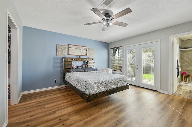 bedroom with ceiling fan, french doors, wood-type flooring, and a textured ceiling