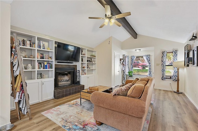 living room with vaulted ceiling with beams, ceiling fan, light hardwood / wood-style flooring, and a fireplace