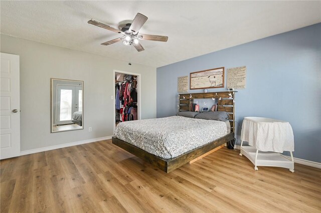 bedroom featuring hardwood / wood-style flooring, ceiling fan, a spacious closet, and a closet