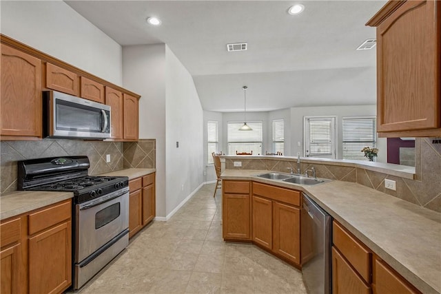 kitchen featuring sink, light tile patterned floors, backsplash, stainless steel appliances, and decorative light fixtures