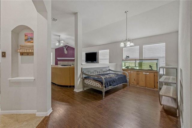 interior space featuring lofted ceiling, dark wood-type flooring, and ceiling fan with notable chandelier