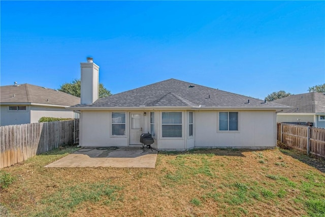 rear view of property with a patio and a lawn