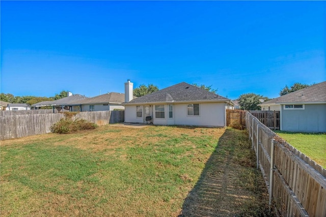 back of house featuring a lawn