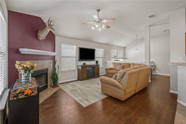 living room featuring hardwood / wood-style flooring, vaulted ceiling, ceiling fan, and a fireplace