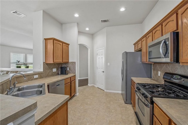 kitchen with appliances with stainless steel finishes, sink, and backsplash