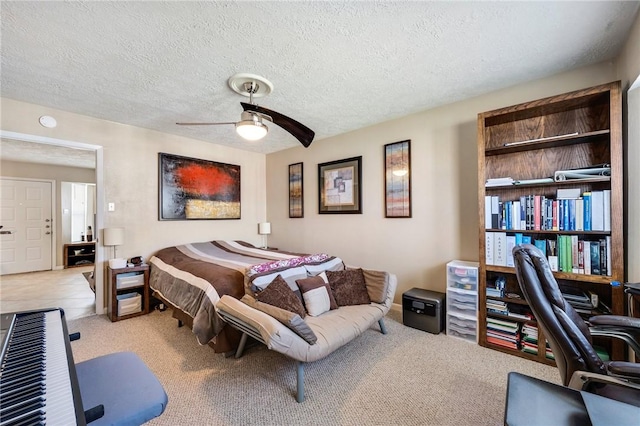 bedroom featuring a ceiling fan, a textured ceiling, and light colored carpet