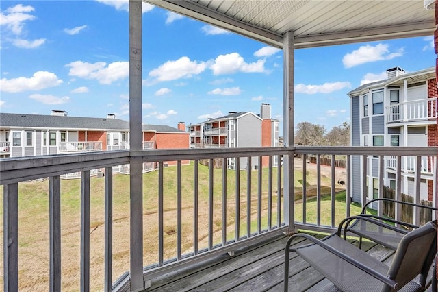 wooden deck featuring a residential view and a lawn