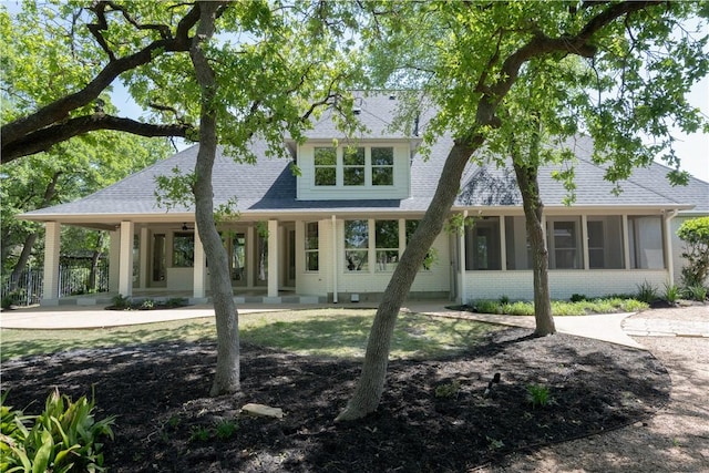 1107 Royal Adelade Dr, College Station, TX 77845 - rear view of property featuring brick siding, roof with shingles, and a sunroom