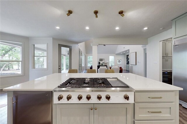 1107 Royal Adelade Dr, College Station, TX 77845 - kitchen with appliances with stainless steel finishes, dark wood-style floors, light countertops, a breakfast bar area, and a textured ceiling