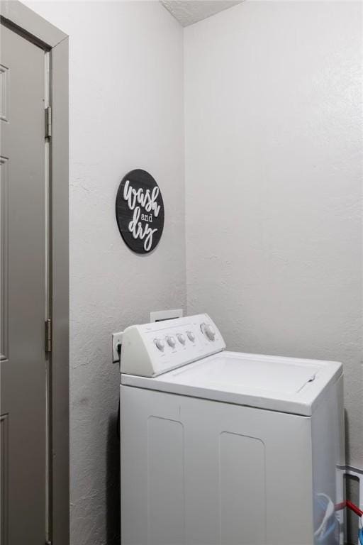 1017 Milner Dr, College Station, TX 77840 - laundry room with washer / dryer and a textured wall