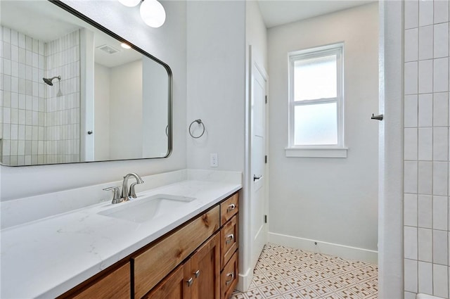 bathroom with vanity and a tile shower