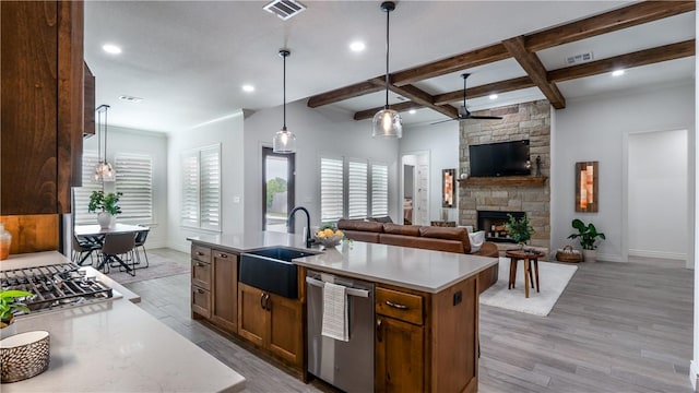 kitchen with a sink, ceiling fan, baseboards, appliances with stainless steel finishes, and visible vents