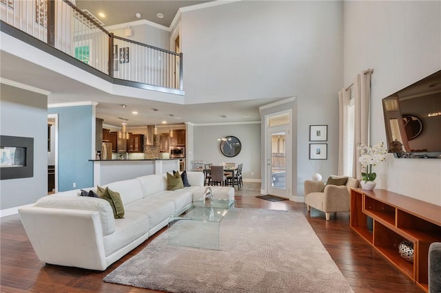 living area featuring crown molding, dark wood-style floors, baseboards, and a towering ceiling