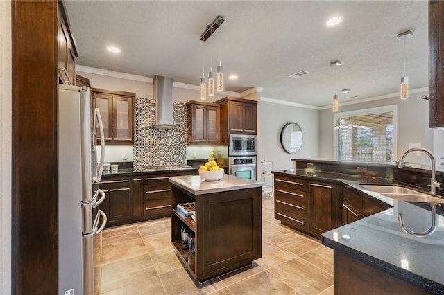 kitchen with visible vents, a sink, appliances with stainless steel finishes, dark countertops, and wall chimney exhaust hood