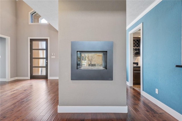 foyer entrance with wood finished floors and baseboards