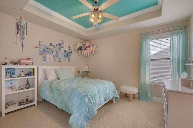 bedroom featuring light carpet, a raised ceiling, ornamental molding, a ceiling fan, and baseboards