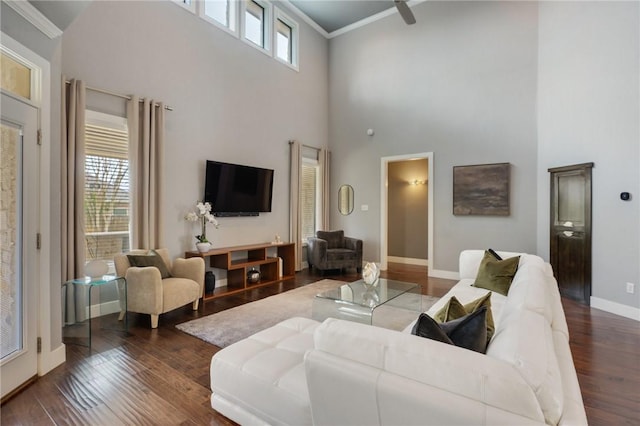 living room featuring a wealth of natural light, crown molding, and wood finished floors