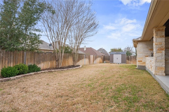 view of yard with a storage unit, an outbuilding, and a fenced backyard