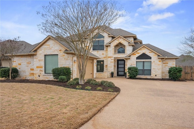 view of front facade featuring driveway, a front lawn, and fence