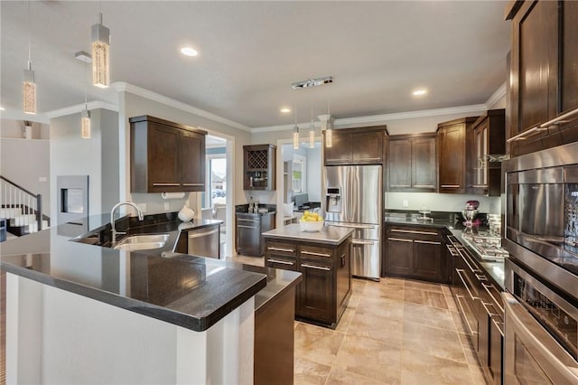 kitchen featuring a sink, dark countertops, dark brown cabinetry, appliances with stainless steel finishes, and a peninsula