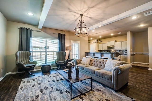 living room featuring dark wood-type flooring, beam ceiling, and a chandelier