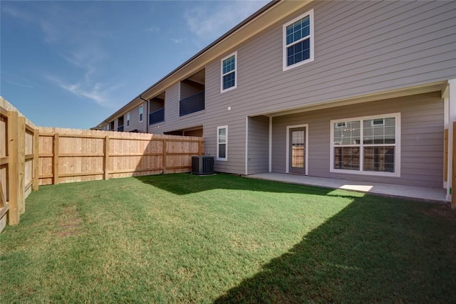 back of house with a lawn and central air condition unit