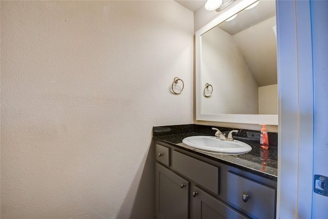 bathroom with lofted ceiling and vanity