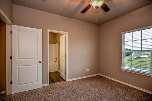 unfurnished bedroom featuring dark colored carpet and connected bathroom