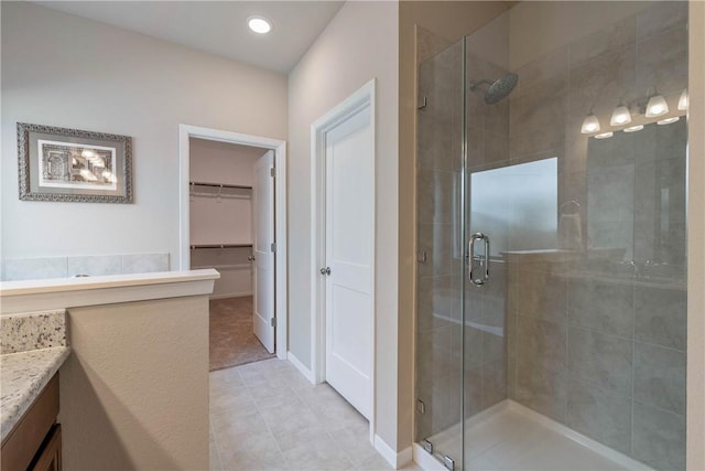 5323 Lyle Pl, Bryan, TX 77807 - full bathroom featuring vanity, a stall shower, a spacious closet, tile patterned flooring, and recessed lighting