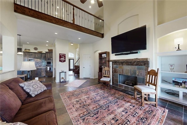 7576 River Ridge Drive, College Station, TX 77845 - living area featuring ceiling fan, a towering ceiling, arched walkways, built in shelves, and a tile fireplace
