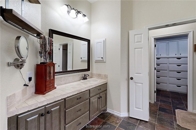 7576 River Ridge Drive, College Station, TX 77845 - bathroom with stone tile floors, vanity, and a closet