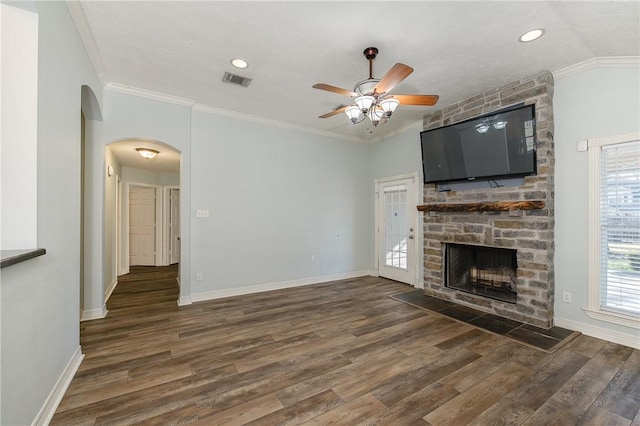 unfurnished living room featuring baseboards, a fireplace, ornamental molding, and wood finished floors