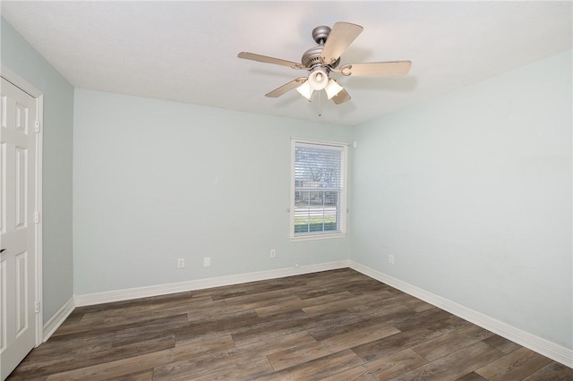 spare room featuring ceiling fan, baseboards, and dark wood-type flooring