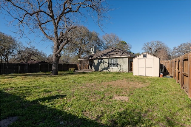 view of yard with an outbuilding, a fenced backyard, and a shed