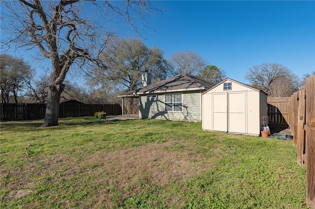 view of yard with a storage shed, a fenced backyard, and an outdoor structure