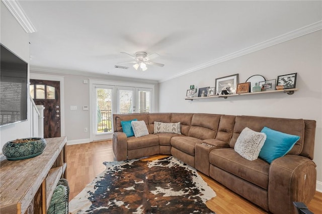 living room featuring crown molding, ceiling fan, and light wood-type flooring