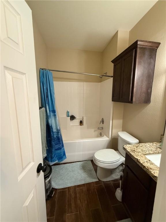 4004 Oaklawn St, Bryan, TX 77801 - bathroom with wood finish floors, toilet, vanity, and  shower combination