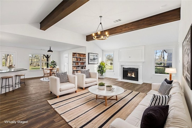 living room featuring lofted ceiling with beams, an inviting chandelier, and dark wood-type flooring