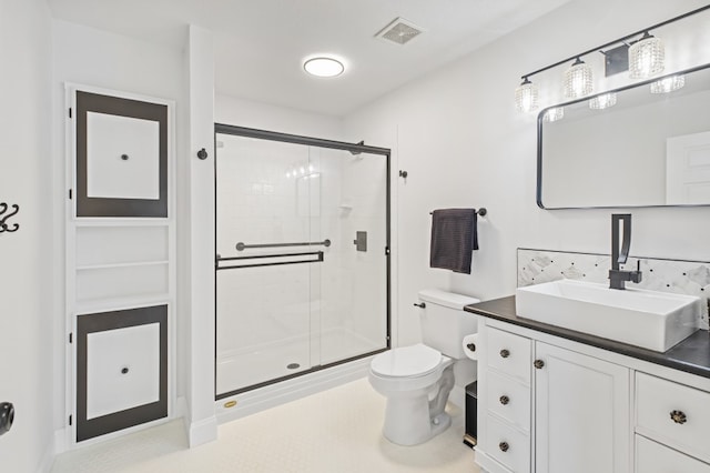 bathroom featuring vanity, tasteful backsplash, toilet, and a shower with shower door