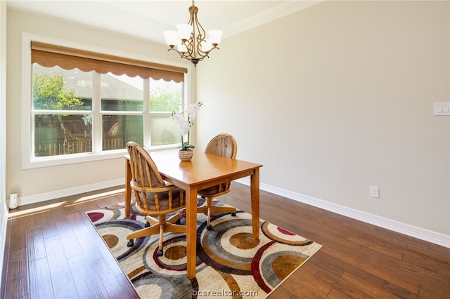 dining room with dark hardwood / wood-style flooring, ornamental molding, and a chandelier