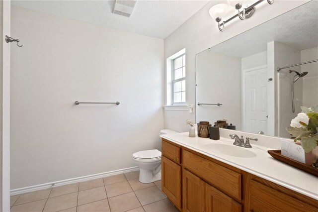 full bath with toilet, a shower, vanity, tile patterned floors, and baseboards