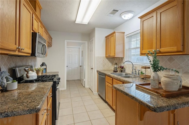 kitchen featuring a sink, stainless steel appliances, visible vents, tasteful backsplash, and light tile patterned flooring