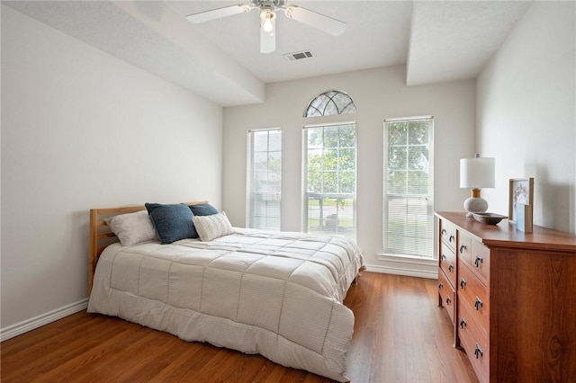 bedroom with ceiling fan, light wood-style flooring, baseboards, and visible vents